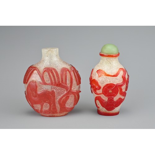 13 - TWO CHINESE GLASS SNUFF BOTTLES. To include a red-overlay glass bottle with horse under a tree. Toge... 