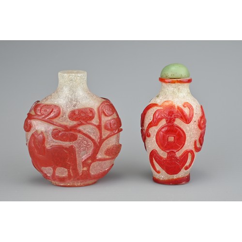 13 - TWO CHINESE GLASS SNUFF BOTTLES. To include a red-overlay glass bottle with horse under a tree. Toge... 