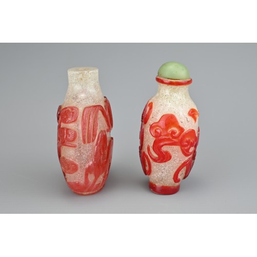 13 - TWO CHINESE GLASS SNUFF BOTTLES. To include a red-overlay glass bottle with horse under a tree. Toge... 