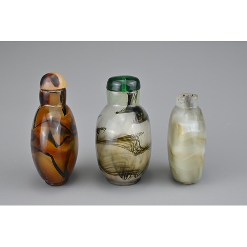 18 - THREE CHINESE GLASS SNUFF BOTTLES. Coloured glass imitation agate with splashes of black. Two with g... 