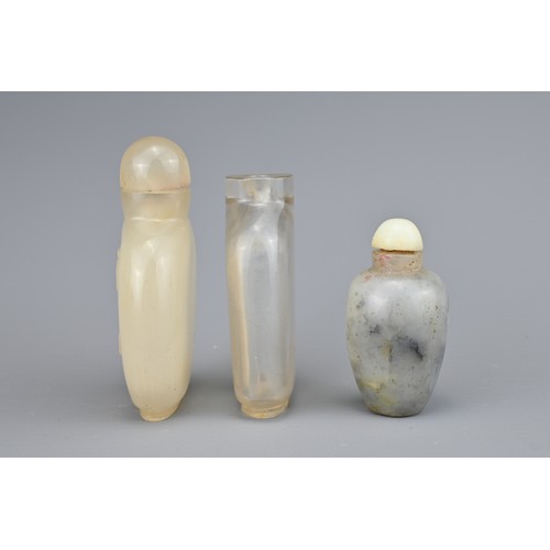 22 - THREE CHINESE SNUFF BOTTLES, QING DYNASTY. Comprising a flattened clear rock crystal bottle; a carve... 