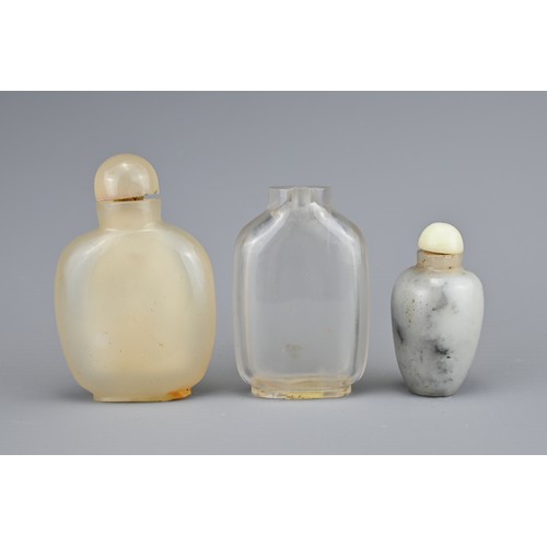 22 - THREE CHINESE SNUFF BOTTLES, QING DYNASTY. Comprising a flattened clear rock crystal bottle; a carve... 