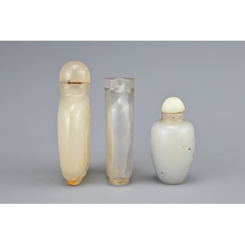 22 - THREE CHINESE SNUFF BOTTLES, QING DYNASTY. Comprising a flattened clear rock crystal bottle; a carve... 