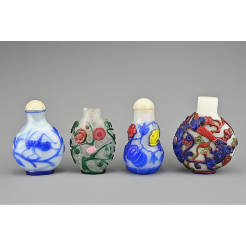 25 - FOUR CHINESE PEKING GLASS SNUFF BOTTLES. Each with coloured overlay on white and clear glass bottles... 