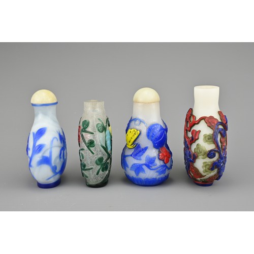 25 - FOUR CHINESE PEKING GLASS SNUFF BOTTLES. Each with coloured overlay on white and clear glass bottles... 