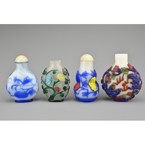 25 - FOUR CHINESE PEKING GLASS SNUFF BOTTLES. Each with coloured overlay on white and clear glass bottles... 