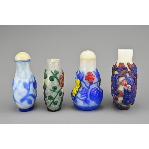 25 - FOUR CHINESE PEKING GLASS SNUFF BOTTLES. Each with coloured overlay on white and clear glass bottles... 