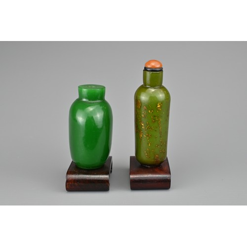 41 - TWO CHINESE GLASS SNUFF BOTTLES, QING DYNASTY. To include a gold-splashed green glass cylindrical bo... 