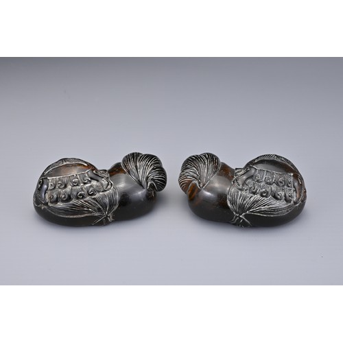 57 - A PAIR OF CHINESE CARVED HORN FOO DOGS, QING DYNASTY. Each recumbent holding a 'pierced' ball. Each ... 