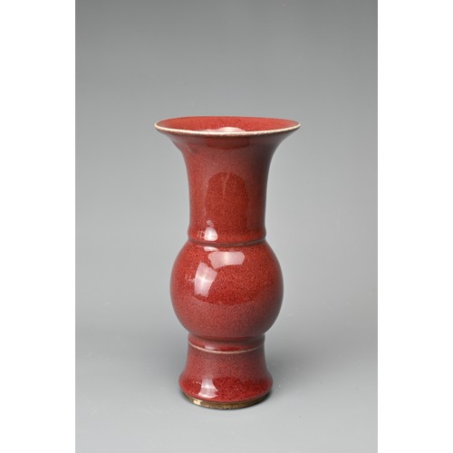 13 - A CHINESE SANG-DE-BOEUF PORCELAIN GU-FORM BEAKER VASE. Covered in a dark red speckled glaze thinning... 