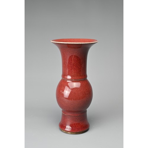 13 - A CHINESE SANG-DE-BOEUF PORCELAIN GU-FORM BEAKER VASE. Covered in a dark red speckled glaze thinning... 