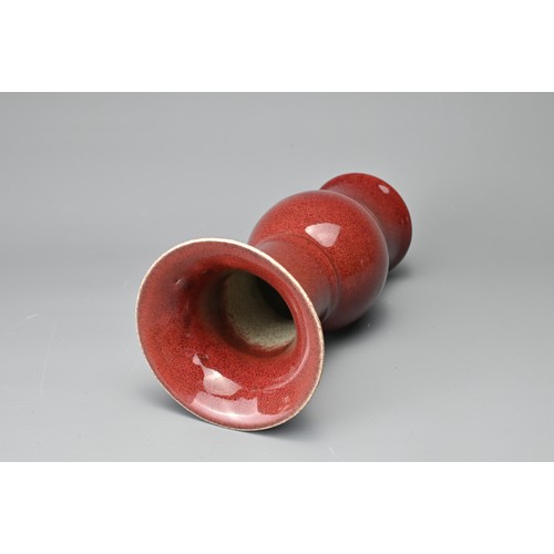 13 - A CHINESE SANG-DE-BOEUF PORCELAIN GU-FORM BEAKER VASE. Covered in a dark red speckled glaze thinning... 