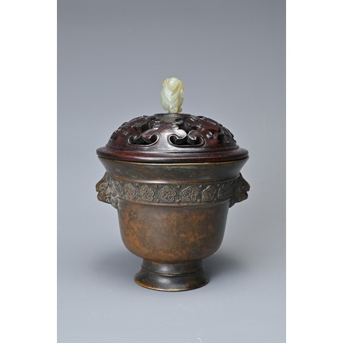 44 - A CHINESE BRONZE CENSER AND COVER. In the form of a cup with lion mask handles and band of floral de... 