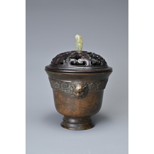 44 - A CHINESE BRONZE CENSER AND COVER. In the form of a cup with lion mask handles and band of floral de... 