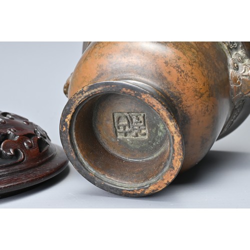 44 - A CHINESE BRONZE CENSER AND COVER. In the form of a cup with lion mask handles and band of floral de... 