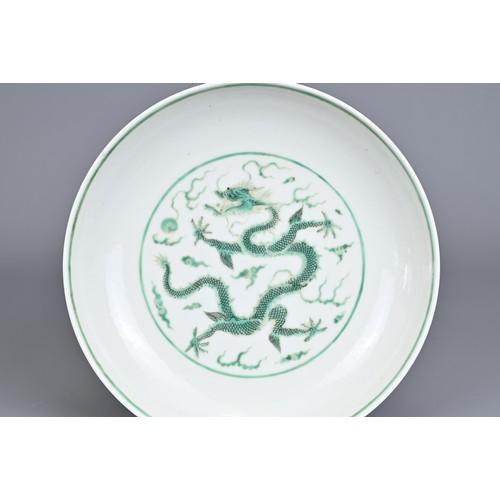 2 - A CHINESE PORCELAIN DRAGON DISH, EARLY 20TH CENTURY. Decorated in green enamel with a dragon chasing... 