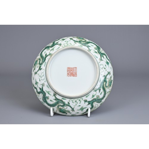 2 - A CHINESE PORCELAIN DRAGON DISH, EARLY 20TH CENTURY. Decorated in green enamel with a dragon chasing... 