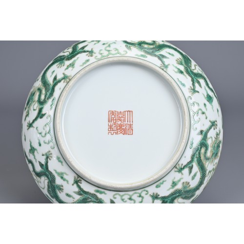 2 - A CHINESE PORCELAIN DRAGON DISH, EARLY 20TH CENTURY. Decorated in green enamel with a dragon chasing... 