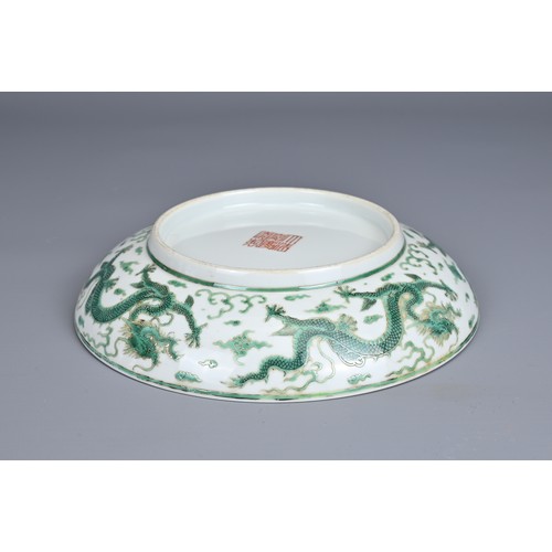 2 - A CHINESE PORCELAIN DRAGON DISH, EARLY 20TH CENTURY. Decorated in green enamel with a dragon chasing... 