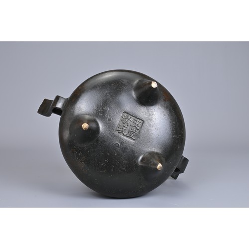 24 - A CHINESE BRONZE TRIPOD CENSER, YU TANG QING WAN MARK. Circular form on three coned feet with raised... 