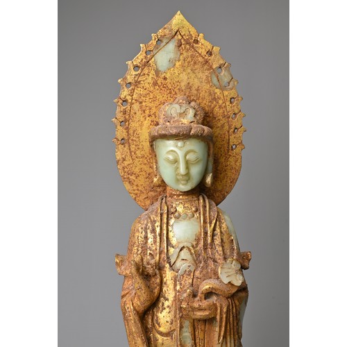 95 - A CHINESE GILT DECORATED CELADON JADE FIGURE OF GUANYIN. The God of Mercy with mandorla standing dre... 