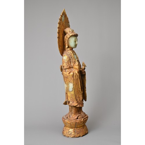 95 - A CHINESE GILT DECORATED CELADON JADE FIGURE OF GUANYIN. The God of Mercy with mandorla standing dre... 