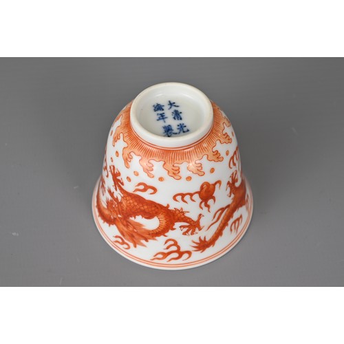 46 - A CHINESE IRON-RED DECORATED PORCELAIN DRAGON CUP, GUANGXU MARK. Of bell shaped form with two dragon... 