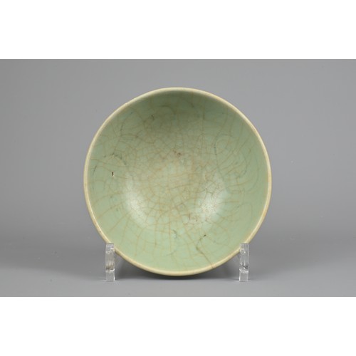 108 - A CHINESE CELADON BOWL, YUAN/MING DYNASTY. Rounded body with short foot and carved floral decoration... 