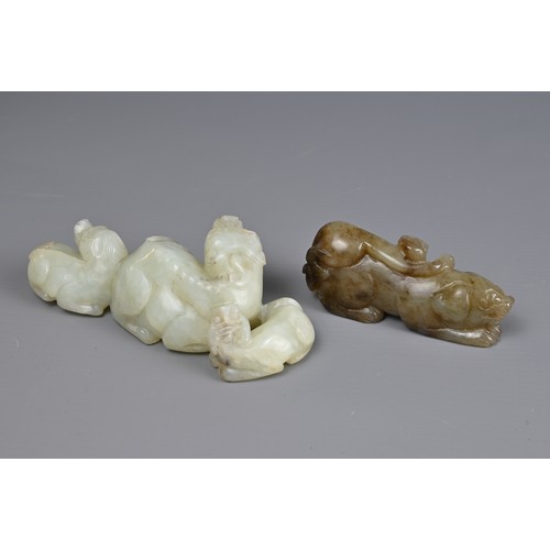 89 - TWO CHINESE JADE CARVINGS. A pale celadon jade carving of a lion group together with a mottled celad... 