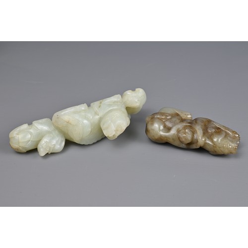 89 - TWO CHINESE JADE CARVINGS. A pale celadon jade carving of a lion group together with a mottled celad... 