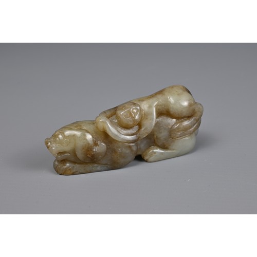 89 - TWO CHINESE JADE CARVINGS. A pale celadon jade carving of a lion group together with a mottled celad... 