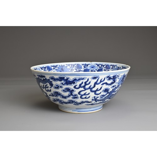 21 - A CHINESE BLUE AND WHITE PORCELAIN BOWL, 19TH CENTURY. Decorated to the exterior with two dragons am... 