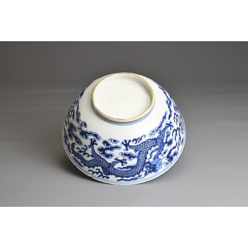 21 - A CHINESE BLUE AND WHITE PORCELAIN BOWL, 19TH CENTURY. Decorated to the exterior with two dragons am... 