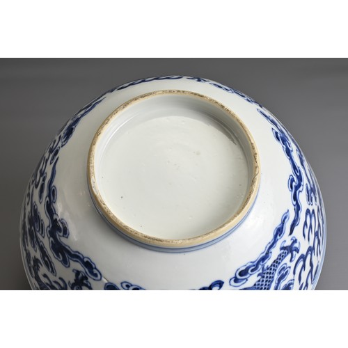 21 - A CHINESE BLUE AND WHITE PORCELAIN BOWL, 19TH CENTURY. Decorated to the exterior with two dragons am... 