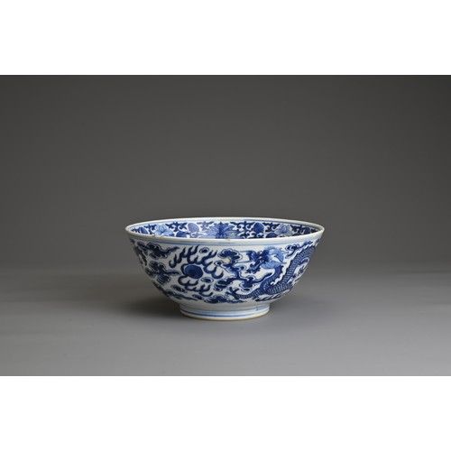 21 - A CHINESE BLUE AND WHITE PORCELAIN BOWL, 19TH CENTURY. Decorated to the exterior with two dragons am... 