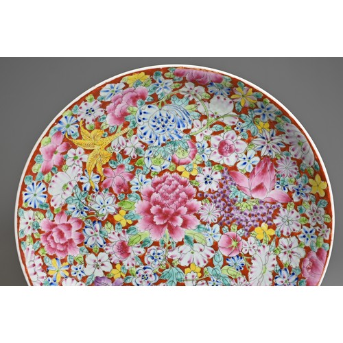 10 - A CHINESE FAMILLE ROSE MILLEFLEURS PORCELAIN DISH, EARLY 20TH CENTURY. On a coral ground densely dec... 