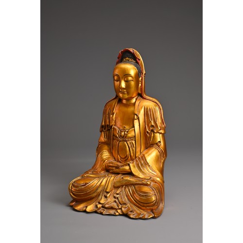 61 - A CHINESE RED LACQUER AND GILT WOOD FIGURE OF GUANYIN. The figure seated in dhyanasana dressed in fl... 