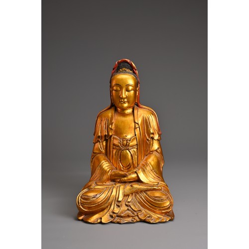 61 - A CHINESE RED LACQUER AND GILT WOOD FIGURE OF GUANYIN. The figure seated in dhyanasana dressed in fl... 