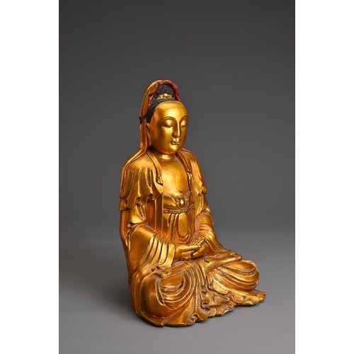 61 - A CHINESE RED LACQUER AND GILT WOOD FIGURE OF GUANYIN. The figure seated in dhyanasana dressed in fl... 