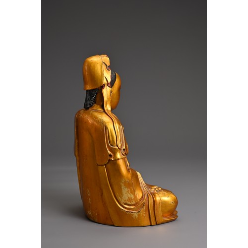 61 - A CHINESE RED LACQUER AND GILT WOOD FIGURE OF GUANYIN. The figure seated in dhyanasana dressed in fl... 