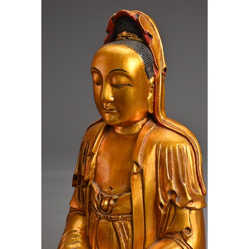 61 - A CHINESE RED LACQUER AND GILT WOOD FIGURE OF GUANYIN. The figure seated in dhyanasana dressed in fl... 