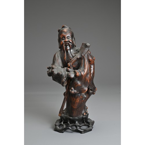 67 - A CHINESE ROOT CARVING OF IMMORTAL, 19/20TH CENTURY. The figure dressed in robes holding a separatel... 