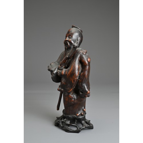 67 - A CHINESE ROOT CARVING OF IMMORTAL, 19/20TH CENTURY. The figure dressed in robes holding a separatel... 