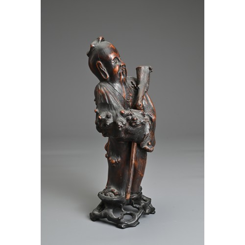 67 - A CHINESE ROOT CARVING OF IMMORTAL, 19/20TH CENTURY. The figure dressed in robes holding a separatel... 