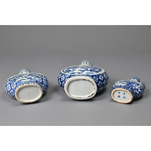 21 - THREE CHINESE BLUE AND WHITE PORCELAIN MOON FLASKS, 19TH CENTURY. Of graduating sizes decorated with... 