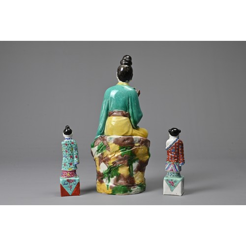 32 - THREE CHINESE GLAZED PORCELAIN FIGURES, 20TH CENTURY. A figure of Guanyin holding a lotus spray with... 