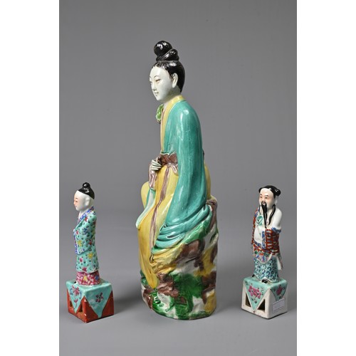 32 - THREE CHINESE GLAZED PORCELAIN FIGURES, 20TH CENTURY. A figure of Guanyin holding a lotus spray with... 