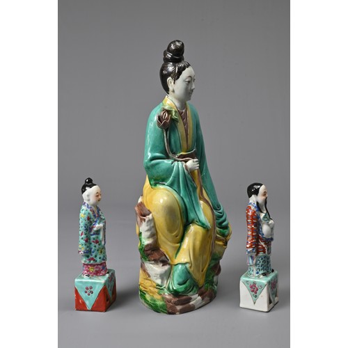 32 - THREE CHINESE GLAZED PORCELAIN FIGURES, 20TH CENTURY. A figure of Guanyin holding a lotus spray with... 