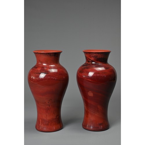 44 - A PAIR OF CHINESE REALGAR GLASS VASES, 19/20TH CENTURY. Each of baluster form carved from red glass ... 