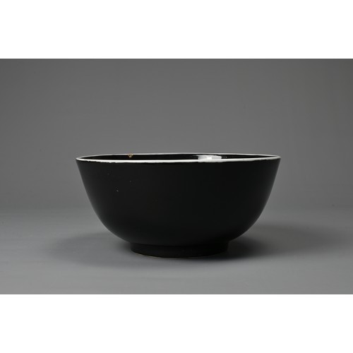 61 - A LARGE CHINESE BLACK GLAZED PORCELAIN BOWL, 20TH CENTURY. Heavily potted round bowl covered in a bl... 